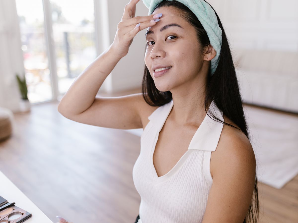 Smiling woman applying a skincare product